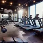 Large group of exercise equipment and machines in a gym without people.